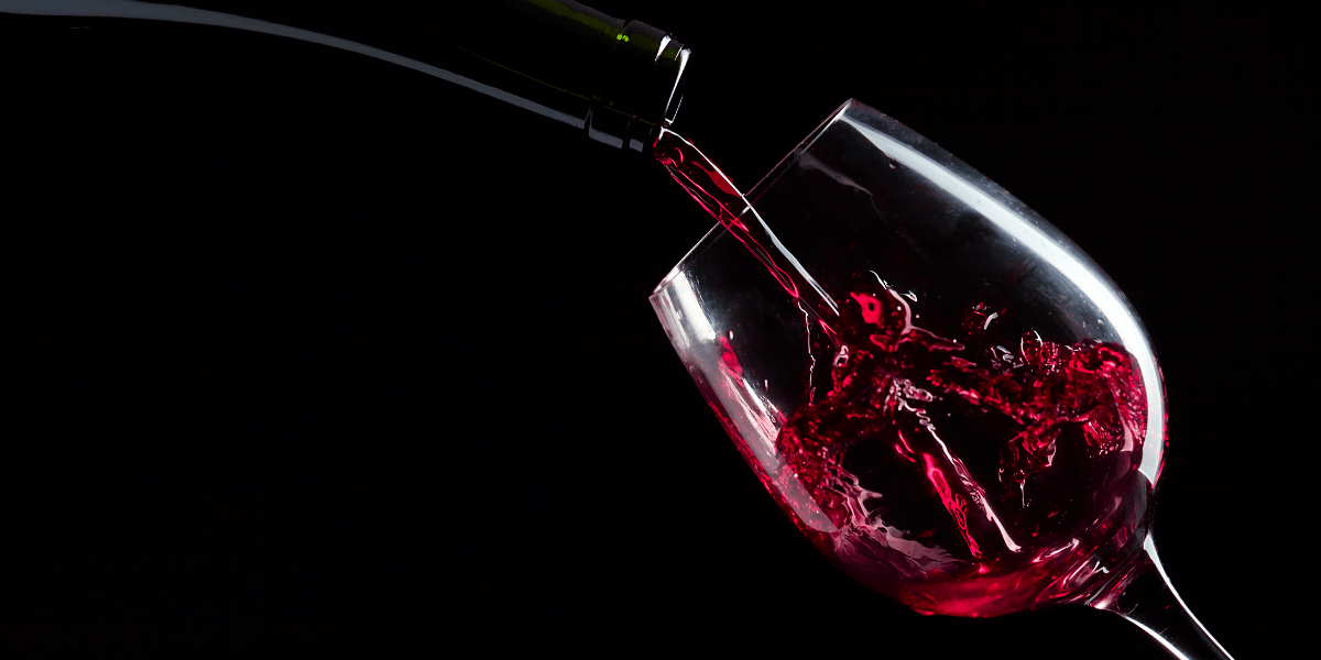 Красное вино. Бокал красного вина. Розовое вино на черном фоне. К чему снится пить во сне вино